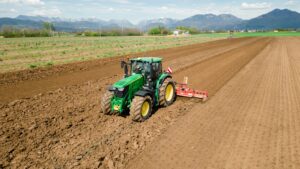 A picture of a rural farming community showcasing the use of farming machinery and equipment, such